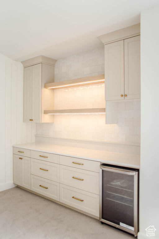 Kitchen featuring wine cooler, light countertops, open shelves, and decorative backsplash