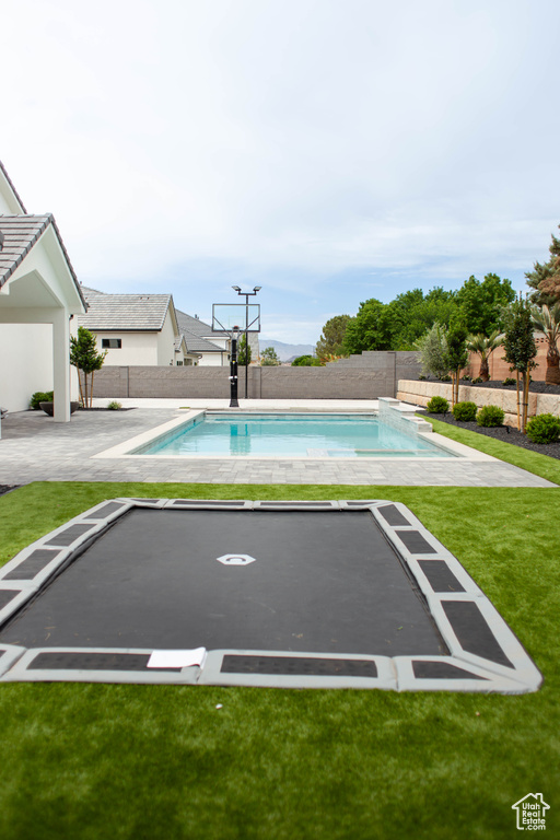 View of swimming pool with a fenced backyard, a patio, a fenced in pool, and a yard