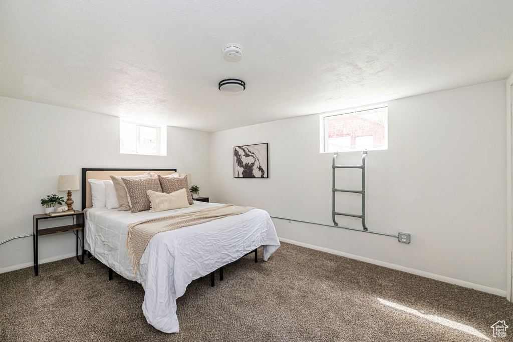 Bedroom with dark carpet and baseboards