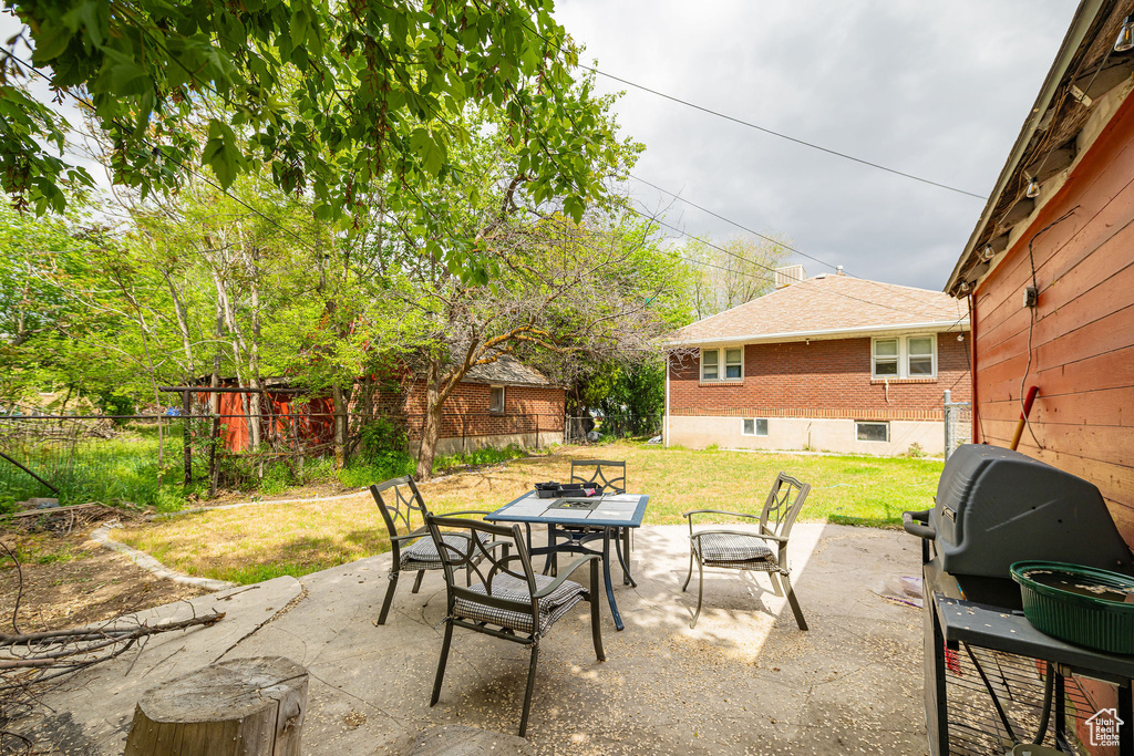 View of patio with outdoor dining space and grilling area
