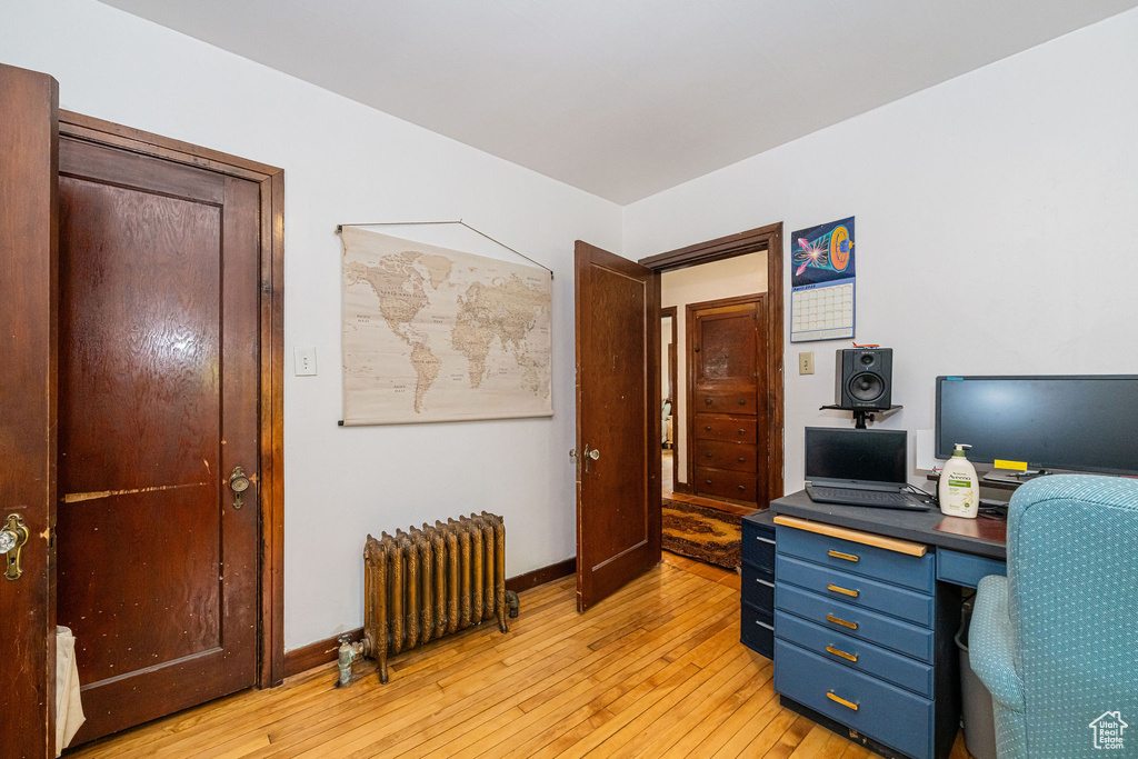 Office area featuring radiator, light wood finished floors, and baseboards