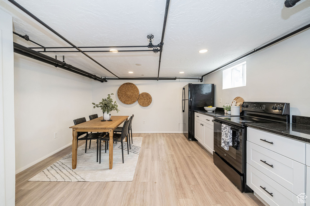 Kitchen featuring black appliances, white cabinets, recessed lighting, light wood-type flooring, and baseboards