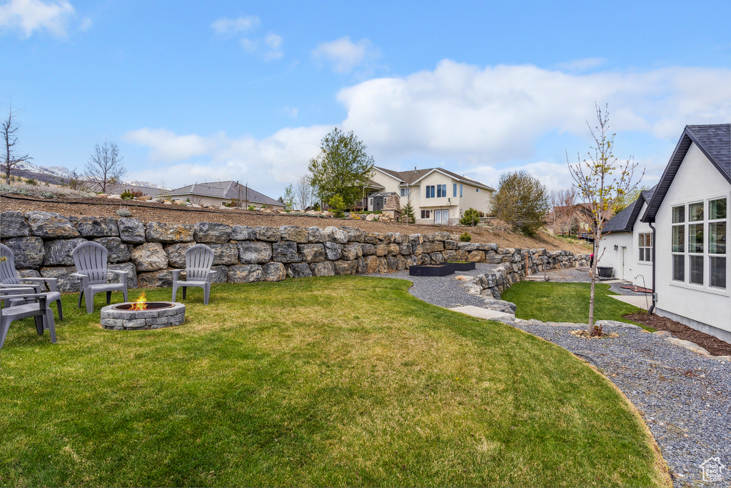 View of yard featuring an outdoor fire pit and a residential view