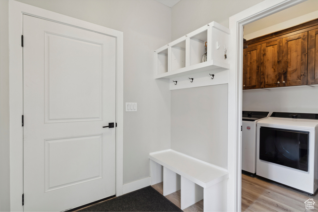Mudroom with washer and dryer and light wood-style flooring
