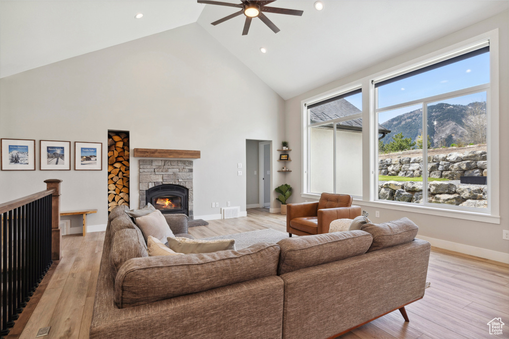 Living area featuring ceiling fan, light wood finished floors, high vaulted ceiling, and a mountain view
