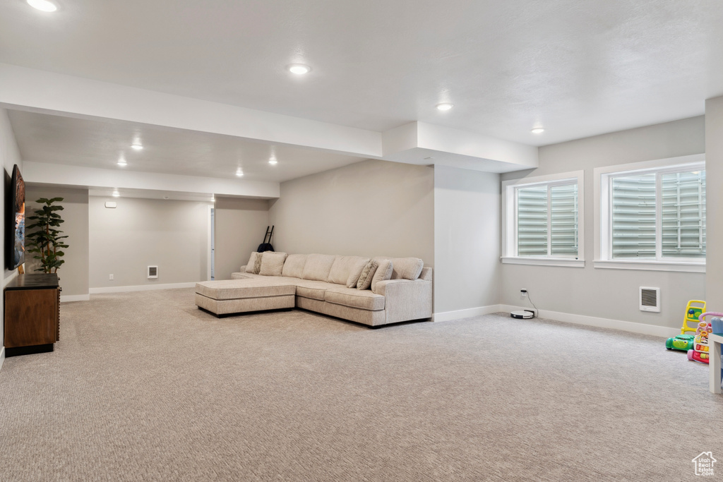 Living area with baseboards, recessed lighting, and light colored carpet
