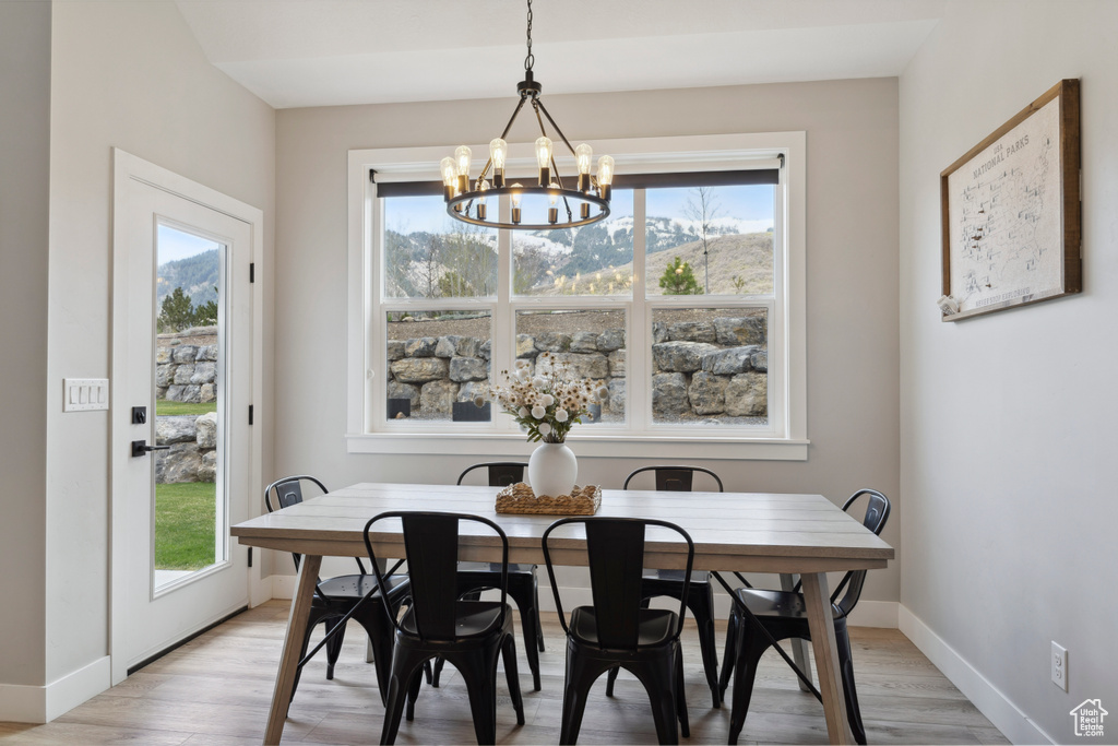 Dining area featuring a chandelier, baseboards, and light wood-style flooring