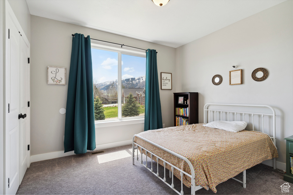 Carpeted bedroom featuring baseboards and visible vents