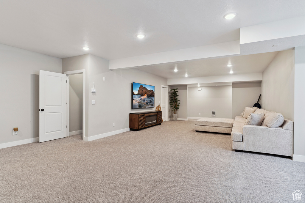 Living room featuring baseboards, recessed lighting, and light colored carpet