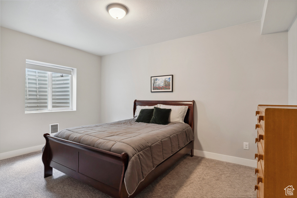Bedroom with carpet flooring, visible vents, and baseboards