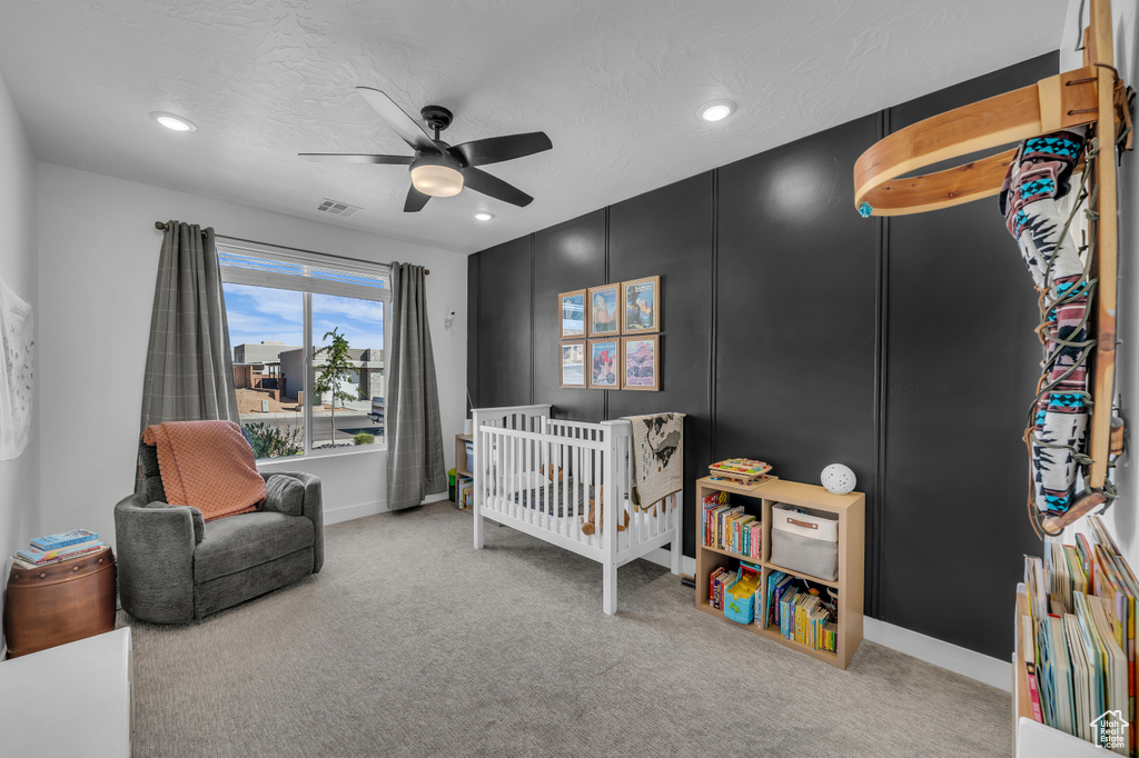 Carpeted bedroom with recessed lighting, a nursery area, a ceiling fan, and baseboards