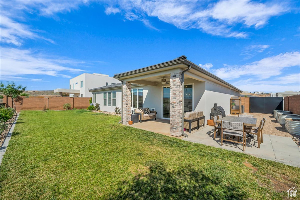 Back of property featuring stucco siding, an outdoor hangout area, a patio, and a ceiling fan