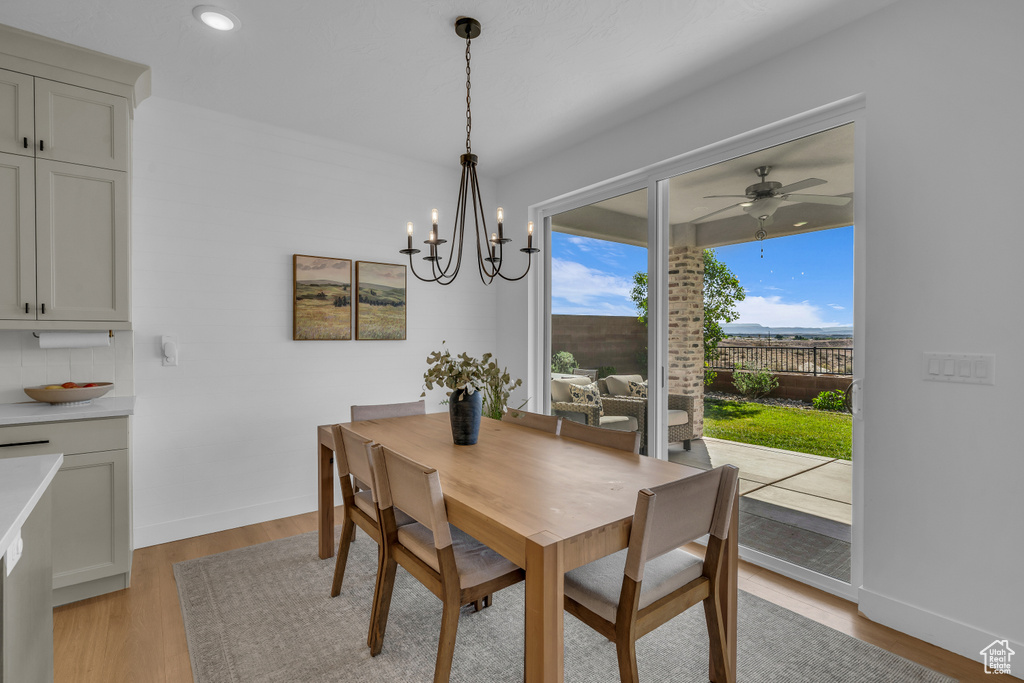 Dining room with light wood-type flooring, a chandelier, baseboards, a ceiling fan, and recessed lighting