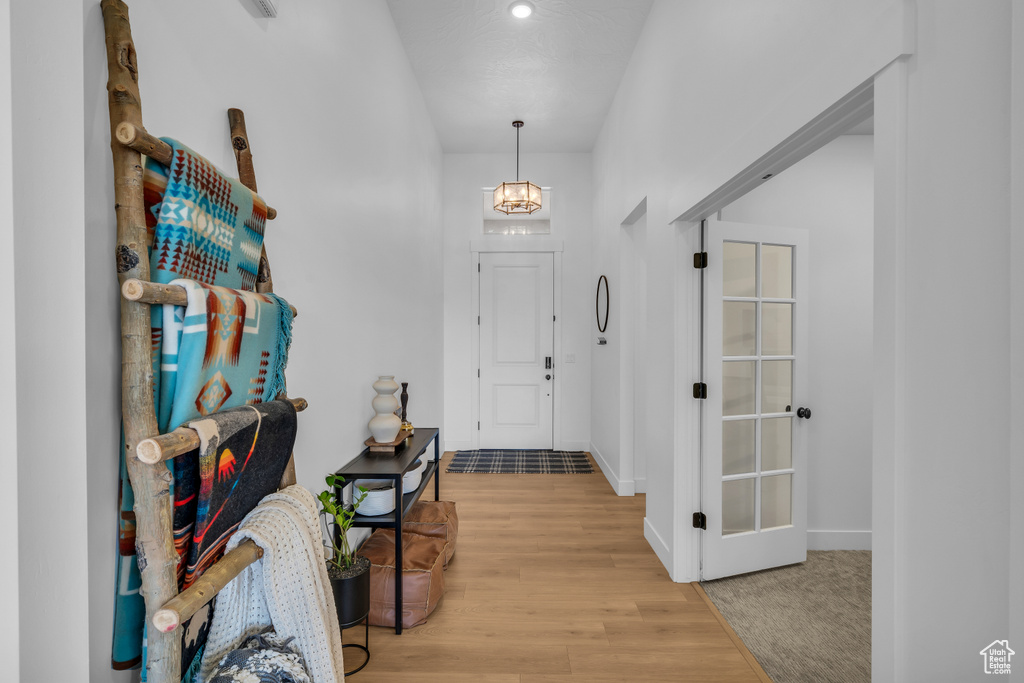 Foyer entrance featuring wood finished floors, baseboards, and a chandelier