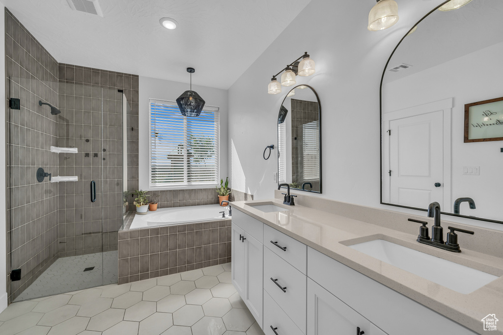 Bathroom with a bath, double vanity, a stall shower, tile patterned floors, and recessed lighting