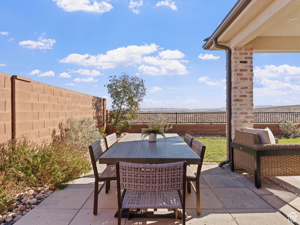 View of patio with outdoor dining space and a fenced backyard