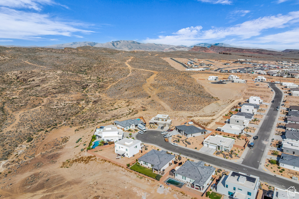 Aerial view of property and surrounding area with a mountainous background, a desert landscape, and nearby suburban area