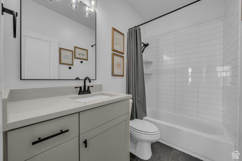 Bathroom featuring vanity, shower / bath combo, toilet, and tile patterned flooring