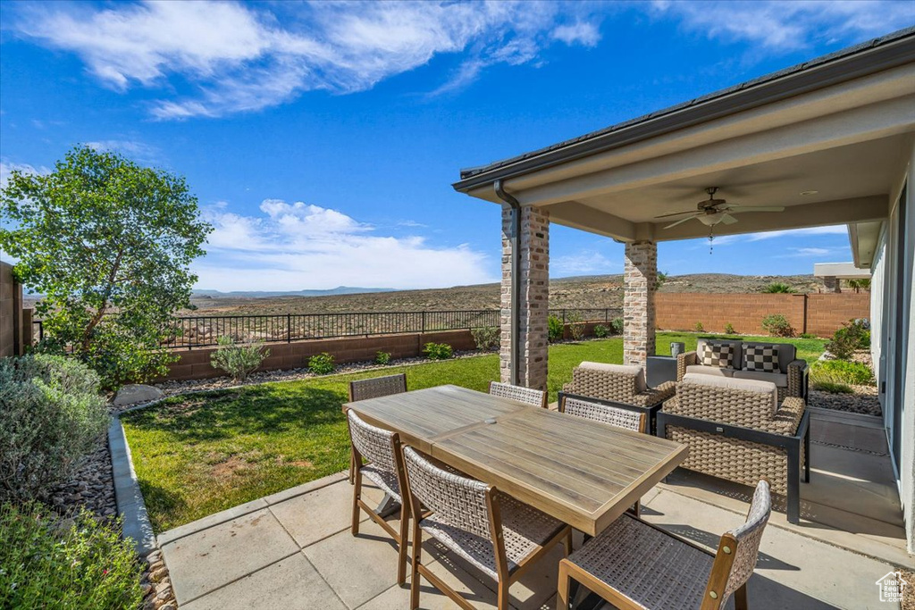View of patio featuring ceiling fan, a mountain view, and outdoor dining area