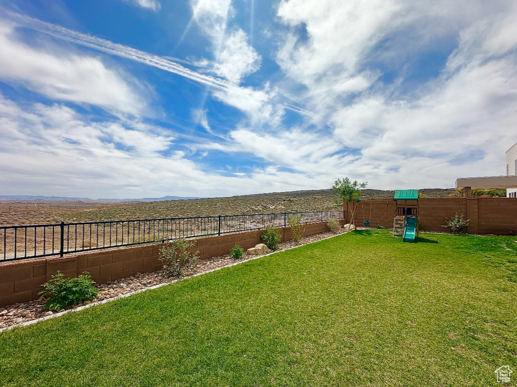 View of yard featuring a playground and a fenced backyard