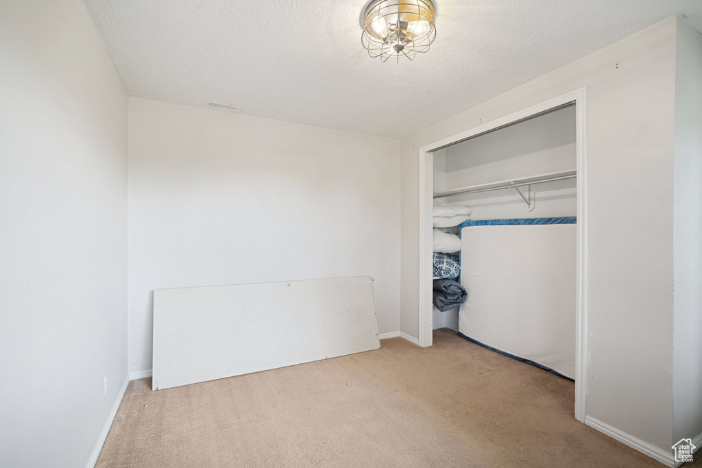 Unfurnished bedroom with baseboards, a closet, and carpet