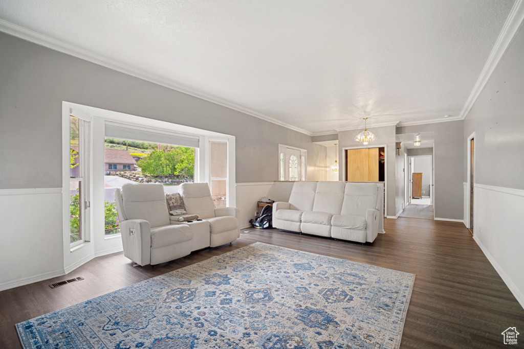 Living room with ornamental molding, visible vents, and dark wood finished floors