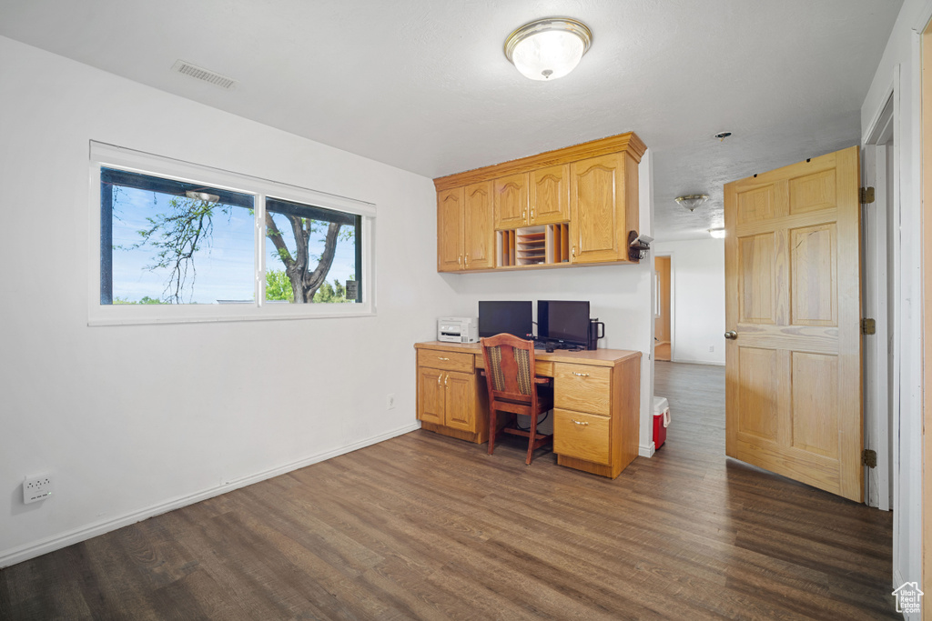 Office with baseboards, visible vents, and dark wood-style floors