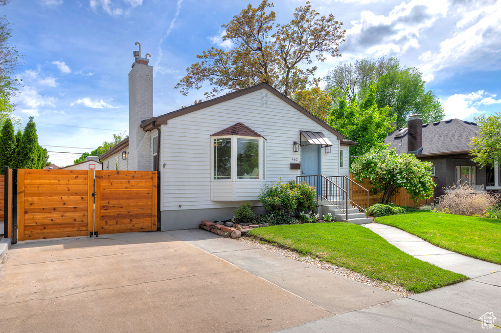 Bungalow-style home featuring a chimney and a gate