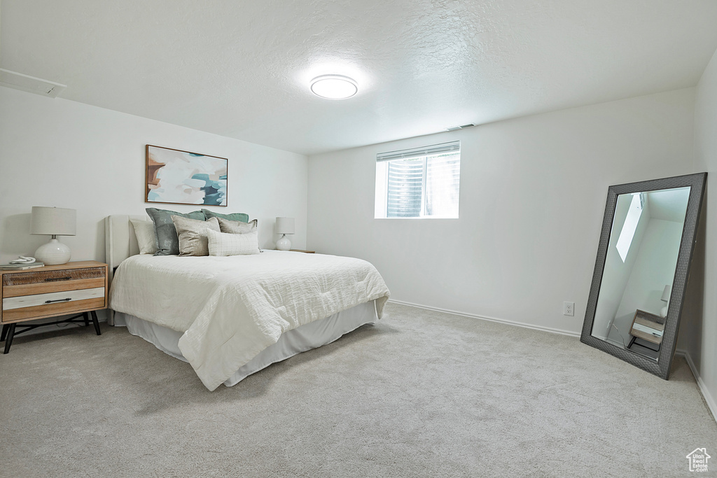 Bedroom featuring carpet floors, baseboards, and a textured ceiling