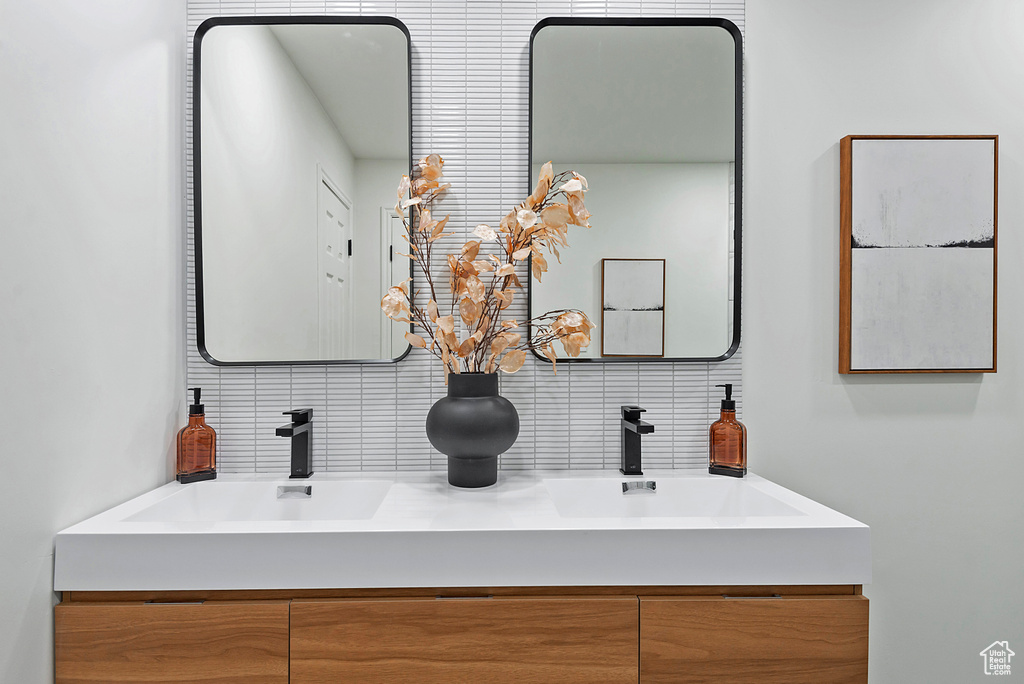 Full bathroom featuring backsplash and double vanity