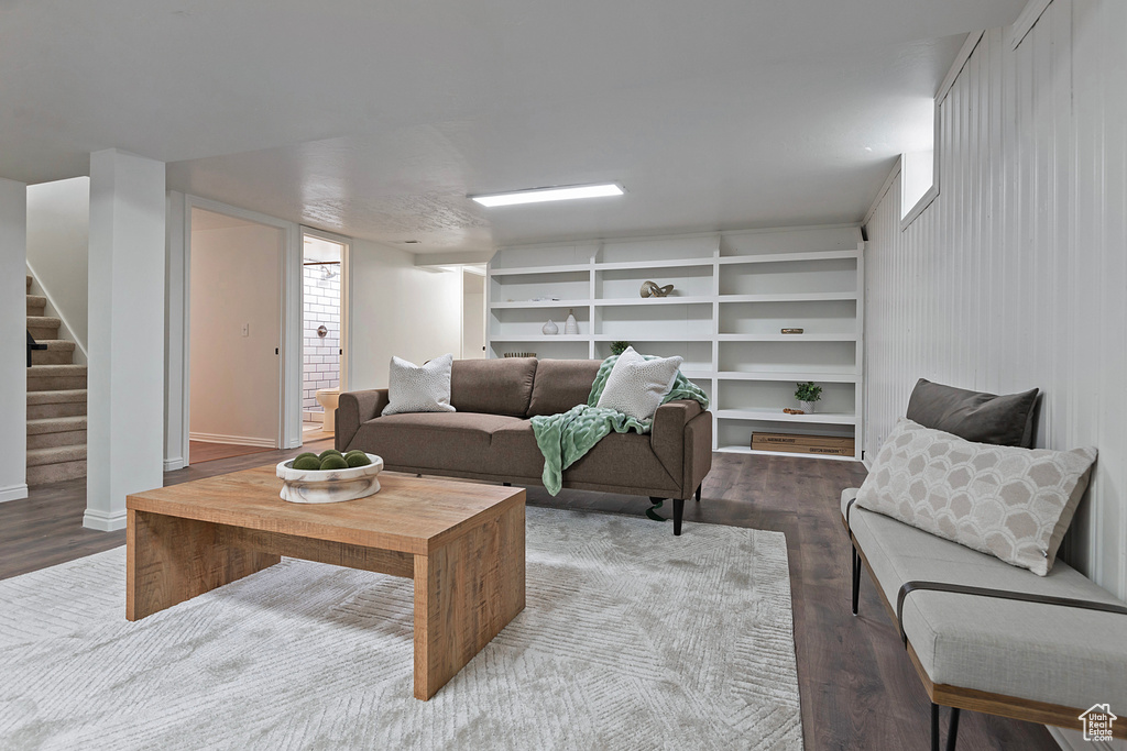 Living area featuring wood finished floors, stairs, and baseboards