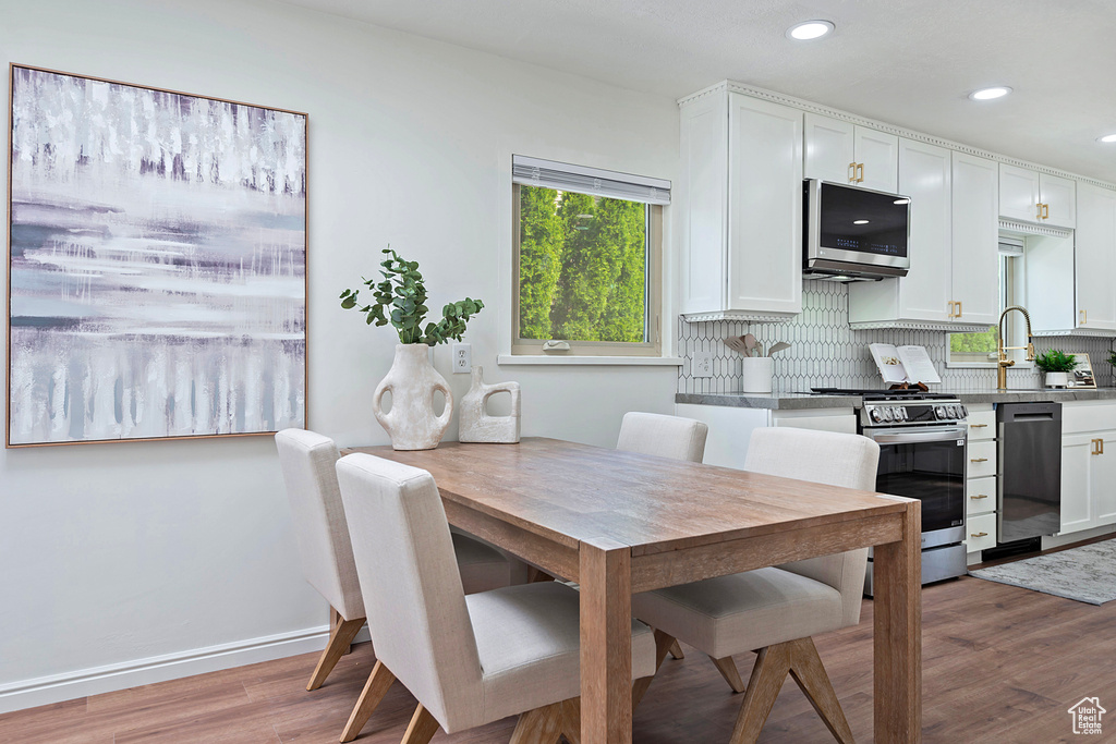 Dining area with light wood finished floors, recessed lighting, and baseboards