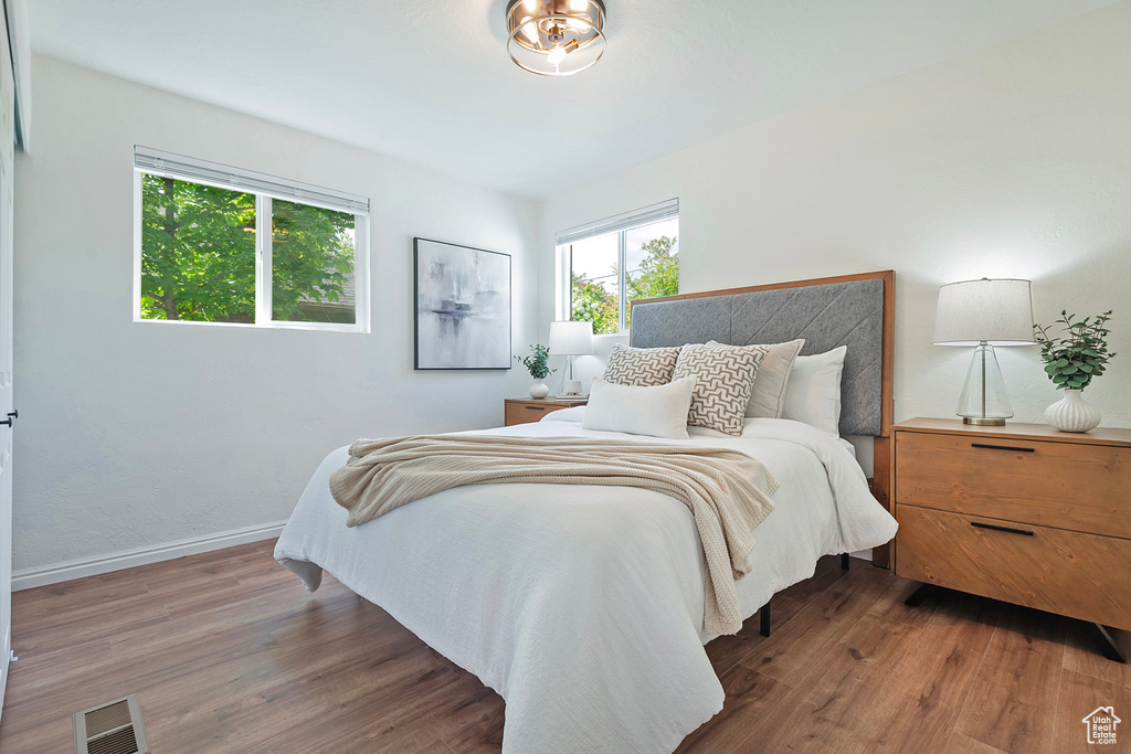 Bedroom with wood finished floors and baseboards
