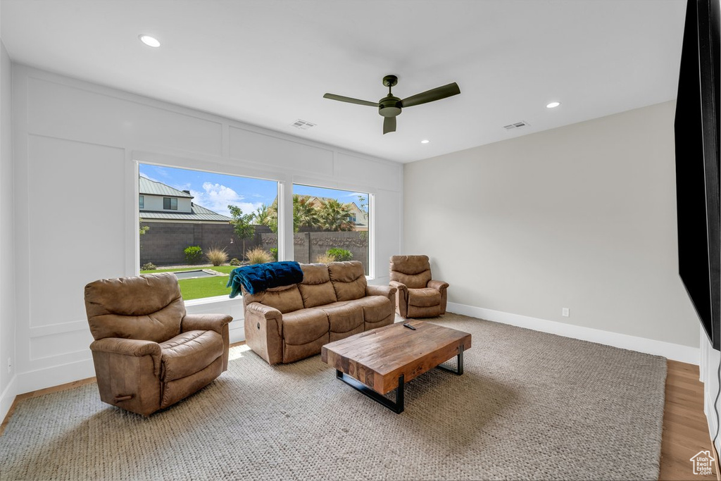 Living room featuring a ceiling fan, recessed lighting, wood finished floors, and baseboards