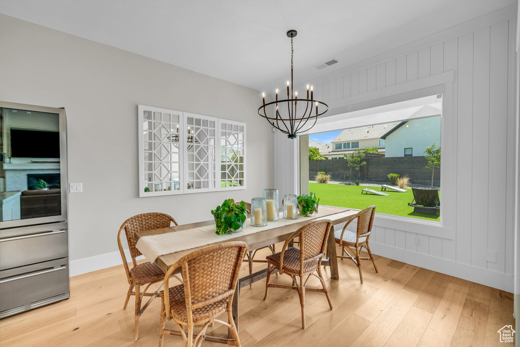 Dining room with hardwood / wood-style floors, a chandelier, and baseboards