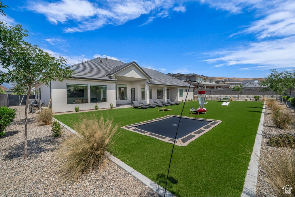 Rear view of property featuring stucco siding and a tile roof