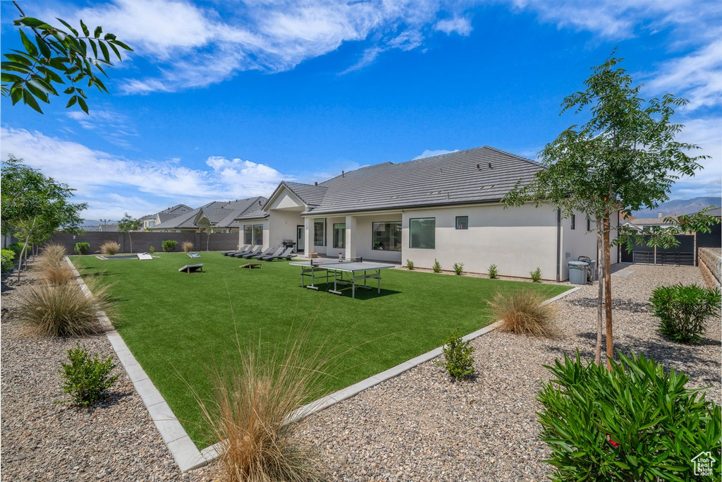 Rear view of property with stucco siding and a tile roof