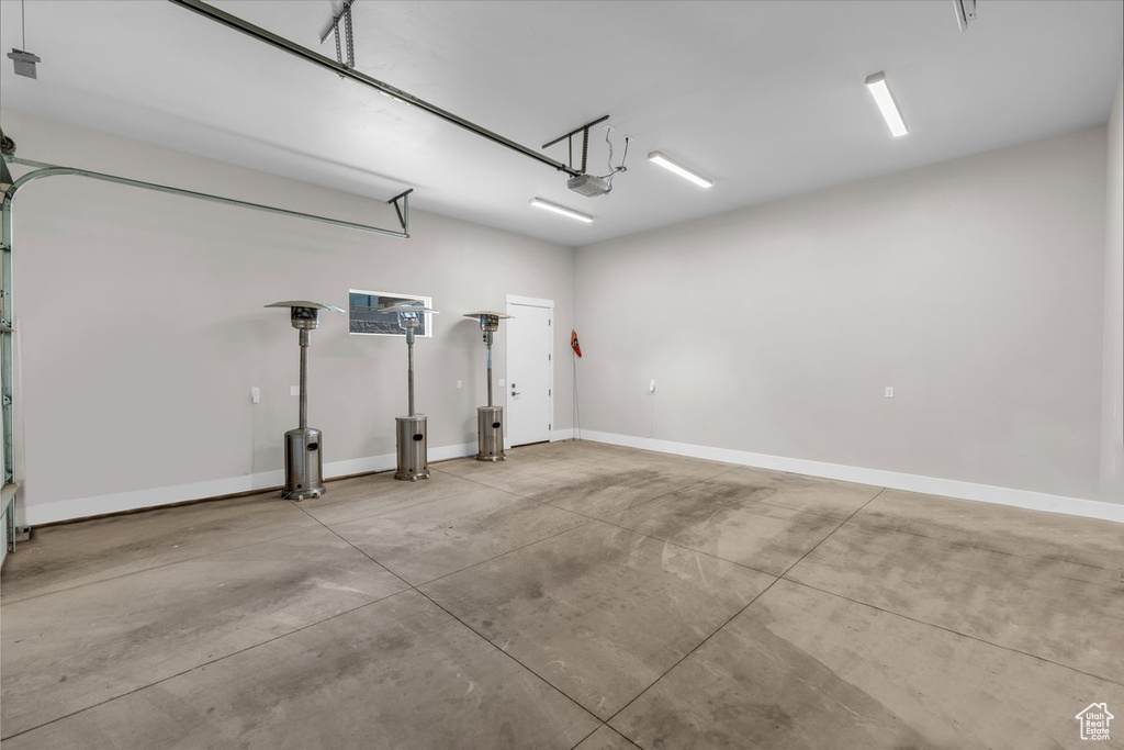 Garage with baseboards and a garage door opener