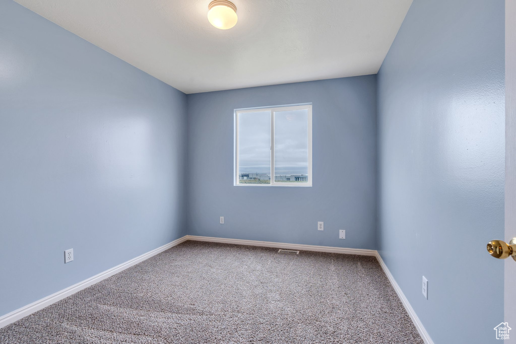 Carpeted empty room with baseboards