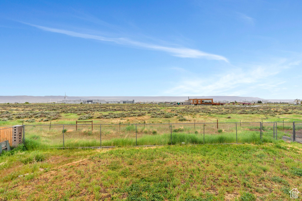 View of yard featuring fence, a view of rural / pastoral area, and a mountain view