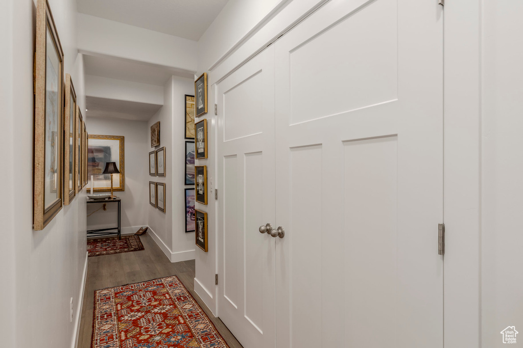 Hall featuring dark wood-style flooring and baseboards
