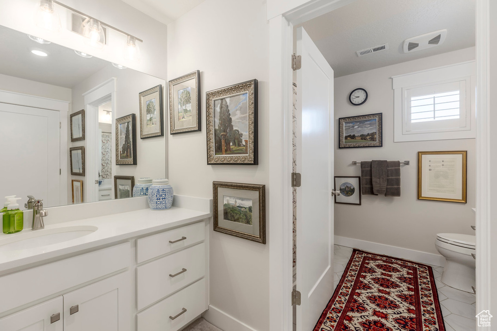 Bathroom with baseboards, vanity, and toilet
