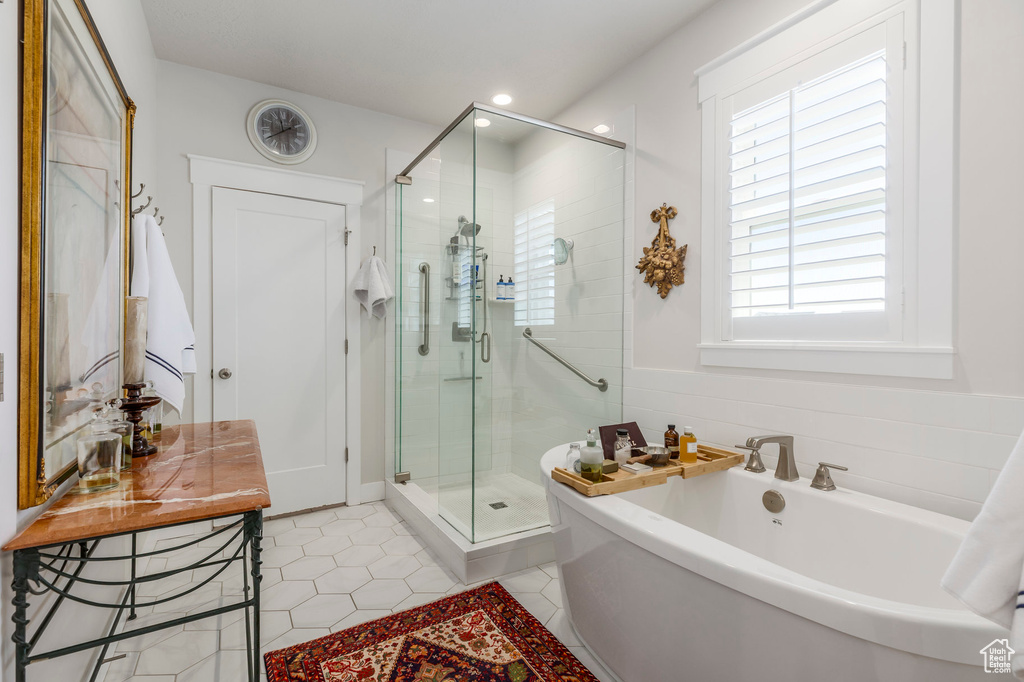 Bathroom with a shower stall, a soaking tub, tile patterned flooring, and recessed lighting