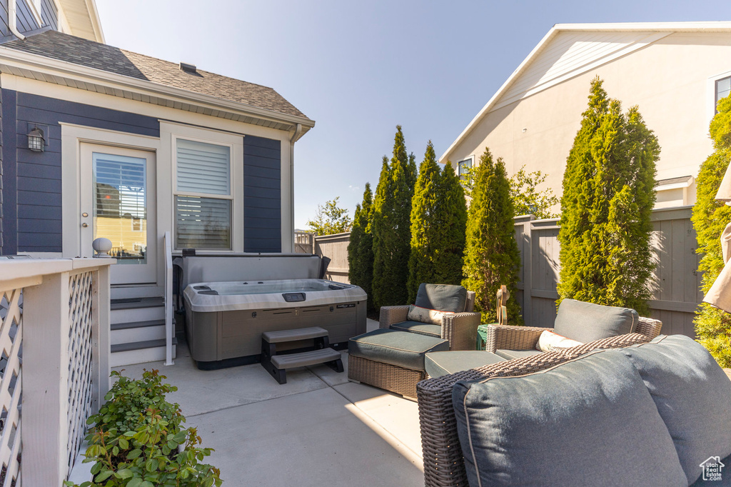 View of patio / terrace with a hot tub, fence, and an outdoor hangout area