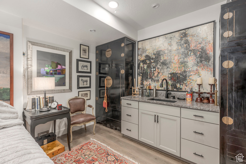 Indoor wet bar featuring light wood finished floors and recessed lighting