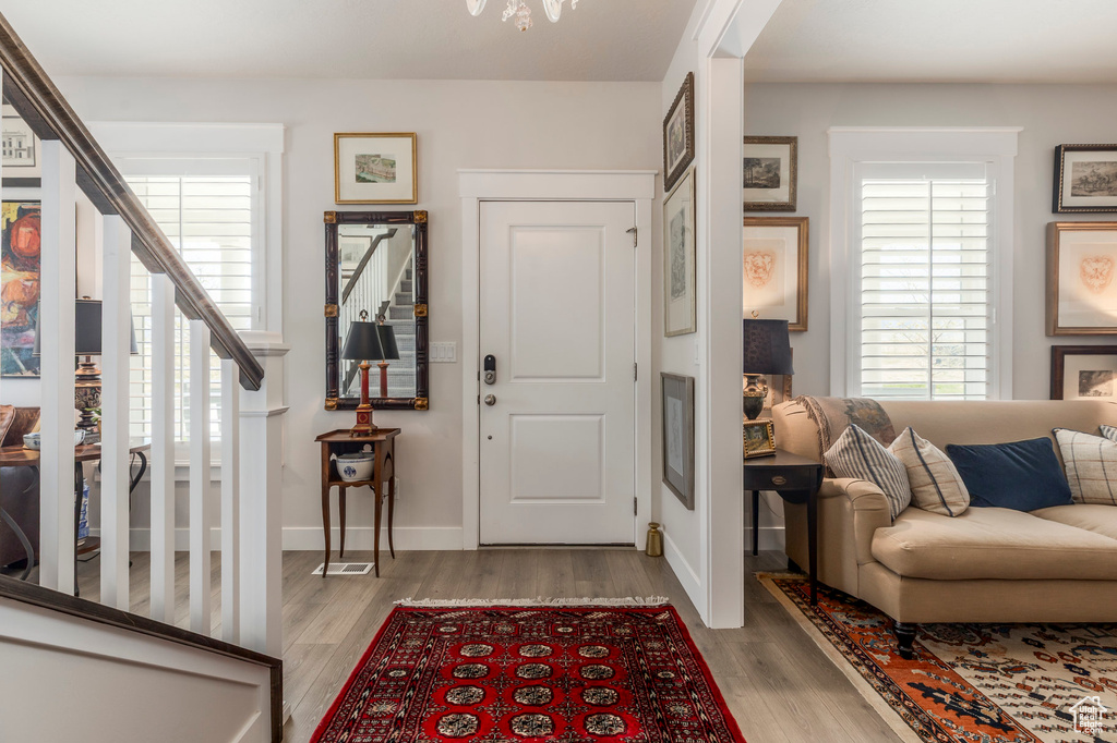Foyer entrance featuring stairway, wood finished floors, and baseboards
