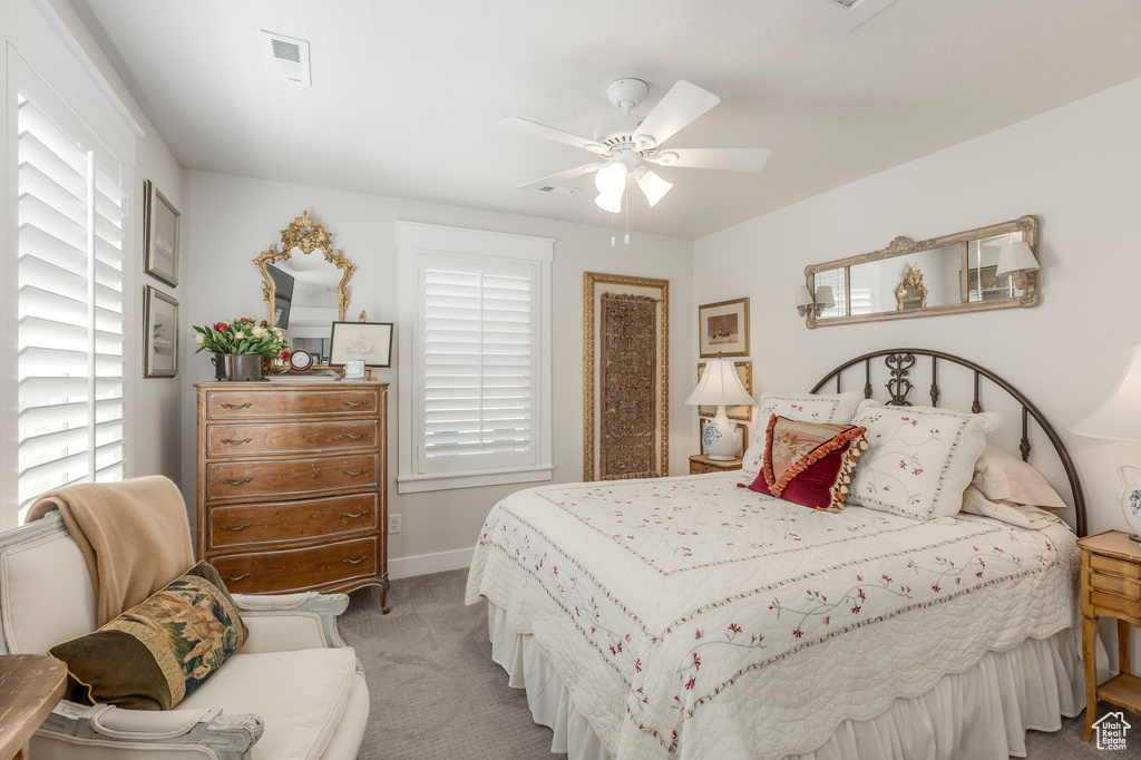 Bedroom featuring light colored carpet, ceiling fan, and baseboards