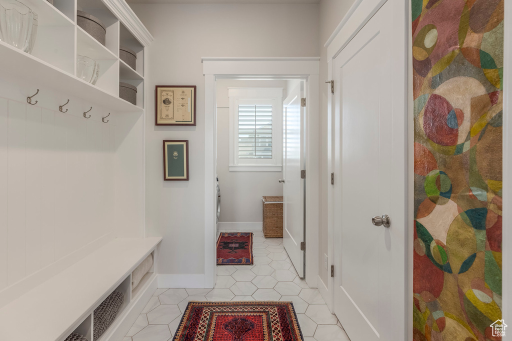 Mudroom featuring light tile patterned floors and baseboards