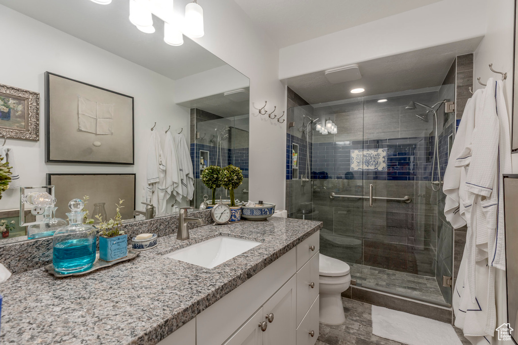 Full bath featuring a stall shower, vanity, and toilet