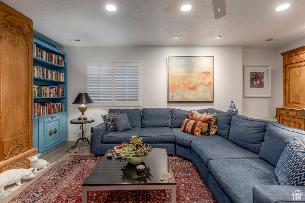 Living area featuring a ceiling fan, recessed lighting, wood finished floors, a textured ceiling, and baseboards